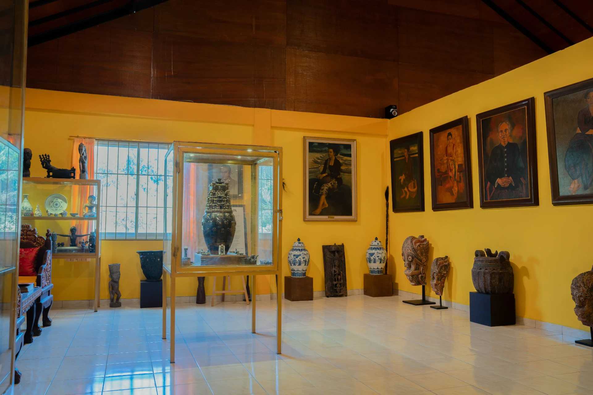 Large white porcelain vessel and framed diplomatic archives on a red gallery wall, Adam Malik Room.