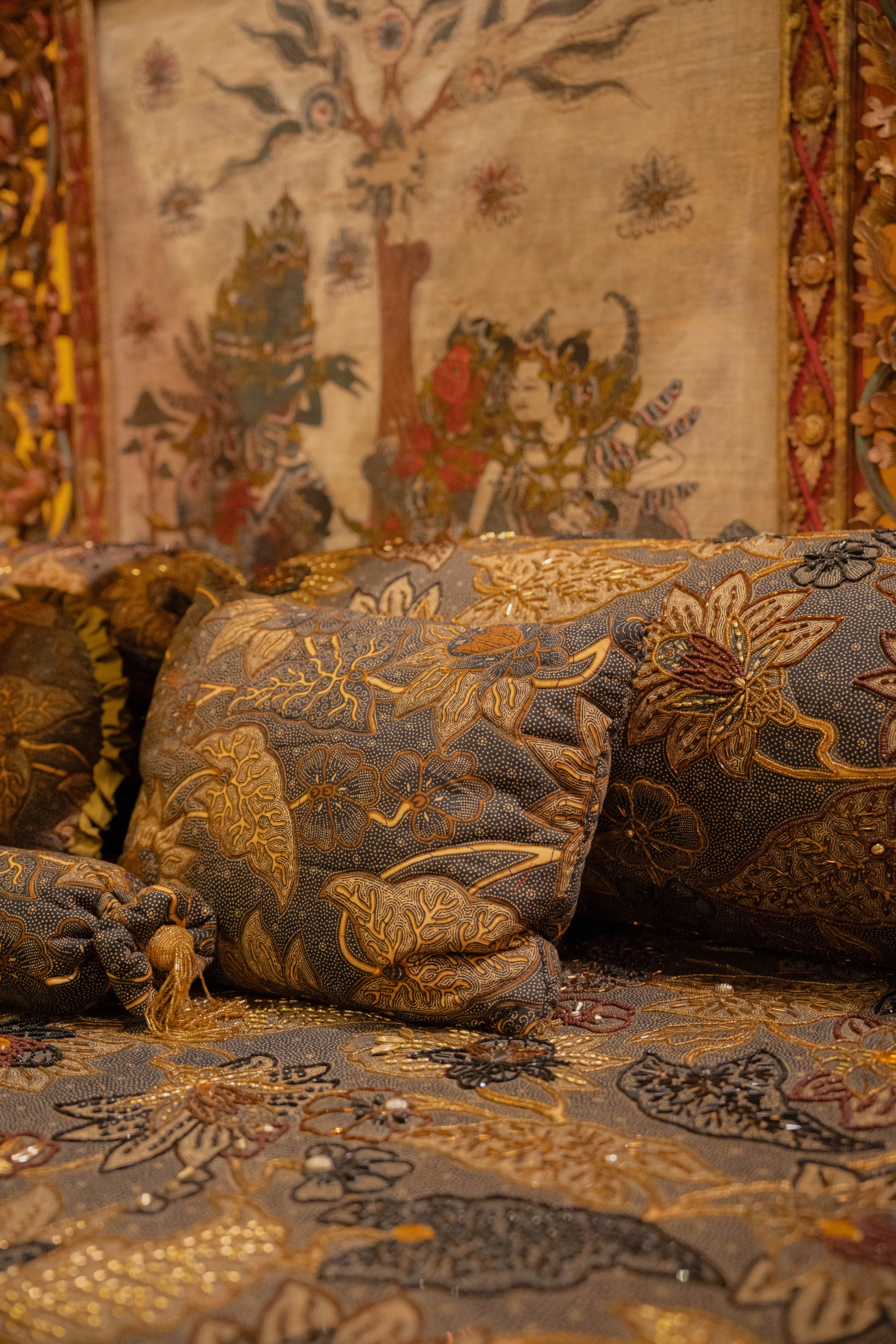 Close-up of ornate Balinese wood carvings and vibrant traditional textiles, Museum Peter Bloch Collection.